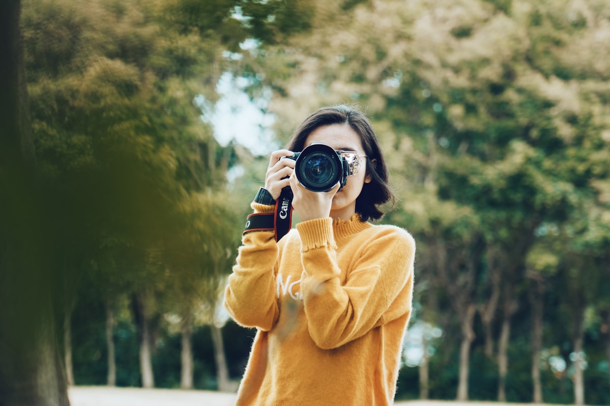 Una fotógrafa con la cámara al ojo durante una sesión al aire libre
